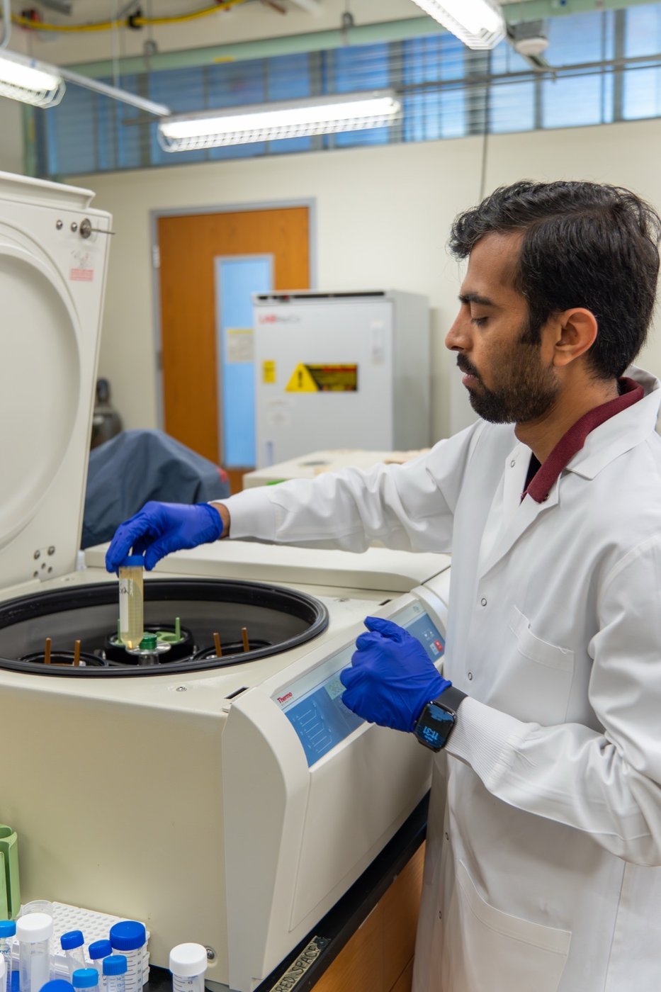 A Soilcea scientist loading a vial into a centrifuge.